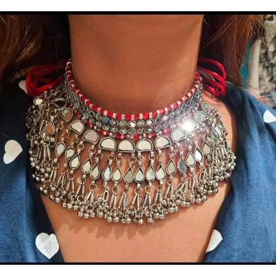 Premium qualityRecreating the opulence of Indian beauty in this beautiful necklace set. Our Silver Oxidised Necklace set is a head-turner with lovely traditional aesthetics that makes its way to a must-have It features intricate floral designs with pearl drops, which adds the perfect amount of drama to the look. It comes with matching jhumki earrings , a ring, pair of bangles, and a nose pin that will complete your look. This necklace set will be the perfect add on to your occasion-specific dre