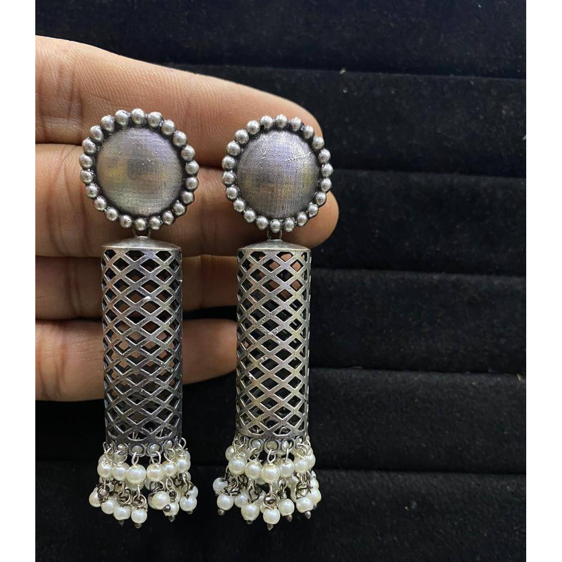 A striking pair of earrings inspired by ghungroos. Hoops with a bunch of playful ghungroos that add a fun element to the look. These Ghungroo Silver Oxidised Hoop Earrings spell elegant and effortless styling. Style this up with your favorite ethnics or pair them up with your casual outfits for a cheeky look