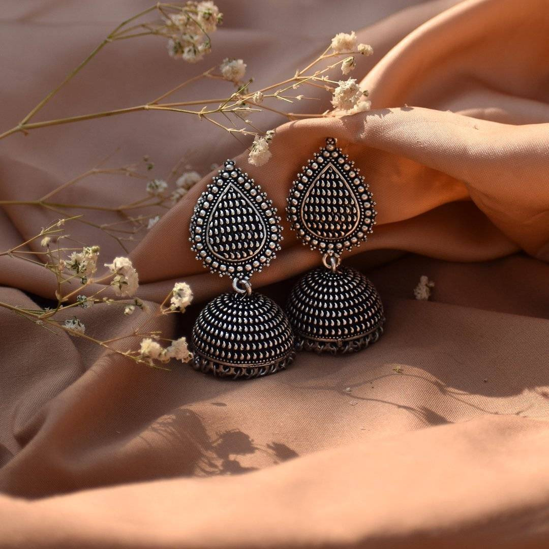 We can't get enough of earrings These earrings feature with Trishul and tiny pearl drops jhumka that surely reflect your lively personality. A pair of earrings that will awaken the jewelry lover in you. Festive styling goes easy with this pair of earrings. Style this up with your outfit for a rich look.