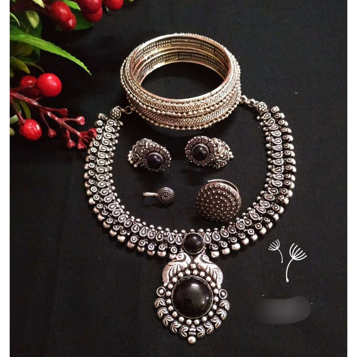 You can never go wrong with statement necklaces. Beautifully ornate with floral motifs , colourful stones & hanging pearls, this one of a kind necklace set will make you fall in love with it instantly. Handcrafted in german silver with oxidized silver plating , this glorious set has a breathtaking impact of instantly adding glam to your outfits. They look splendid with your sarees , low neck kurtas or even with your lehengas.