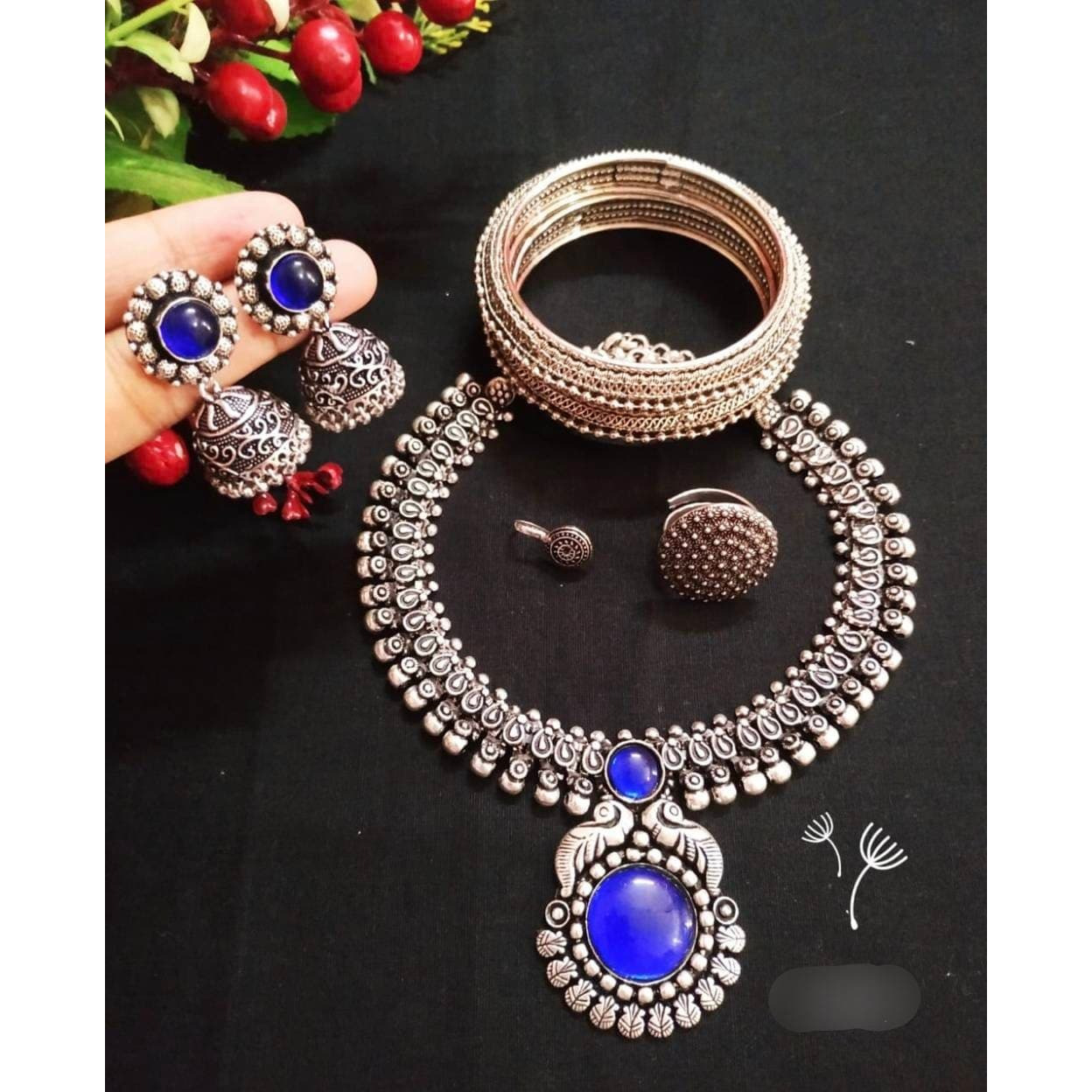 You can never go wrong with statement necklaces. Beautifully ornate with floral motifs , colourful stones & hanging pearls, this one of a kind necklace set will make you fall in love with it instantly. Handcrafted in german silver with oxidized silver plating , this glorious set has a breathtaking impact of instantly adding glam to your outfits. They look splendid with your sarees , low neck kurtas or even with your lehengas.