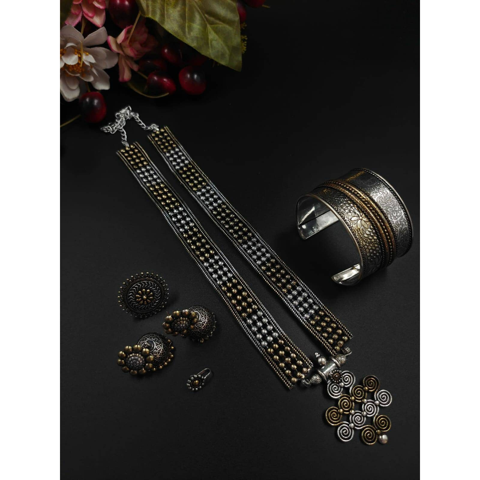 Beautifully ornate with floral motifs , brilliant stones & hanging pearls, this one of a kind necklace set will make you fall in love with it instantly. Handcrafted in german silver with oxidized silver plating , this glorious set has a breathtaking impact of instantly adding glam to your outfits. They look splendid with your sarees , low neck kurtas or even with your lehangas.