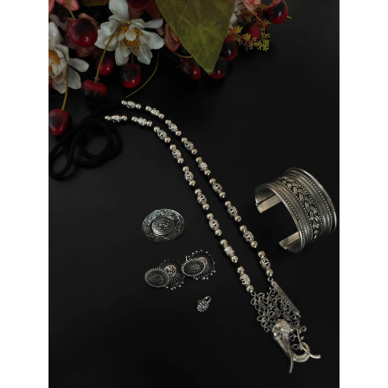 You can never go wrong with a statement oxidized necklace set. Beautifully ornated withfloral motifs, stones studded with dreamy white pearl drops, this unique necklace set willmake you fall in love with it instantly and is available in six different colours like red, green,black, dark blue, light blue, and multicolour. The gorgeous statement earrings add a bling toyour outfit. Pair it with your saree, low neck kurta, or lehenga and look stunning It isnecessary to keep this product away from ha