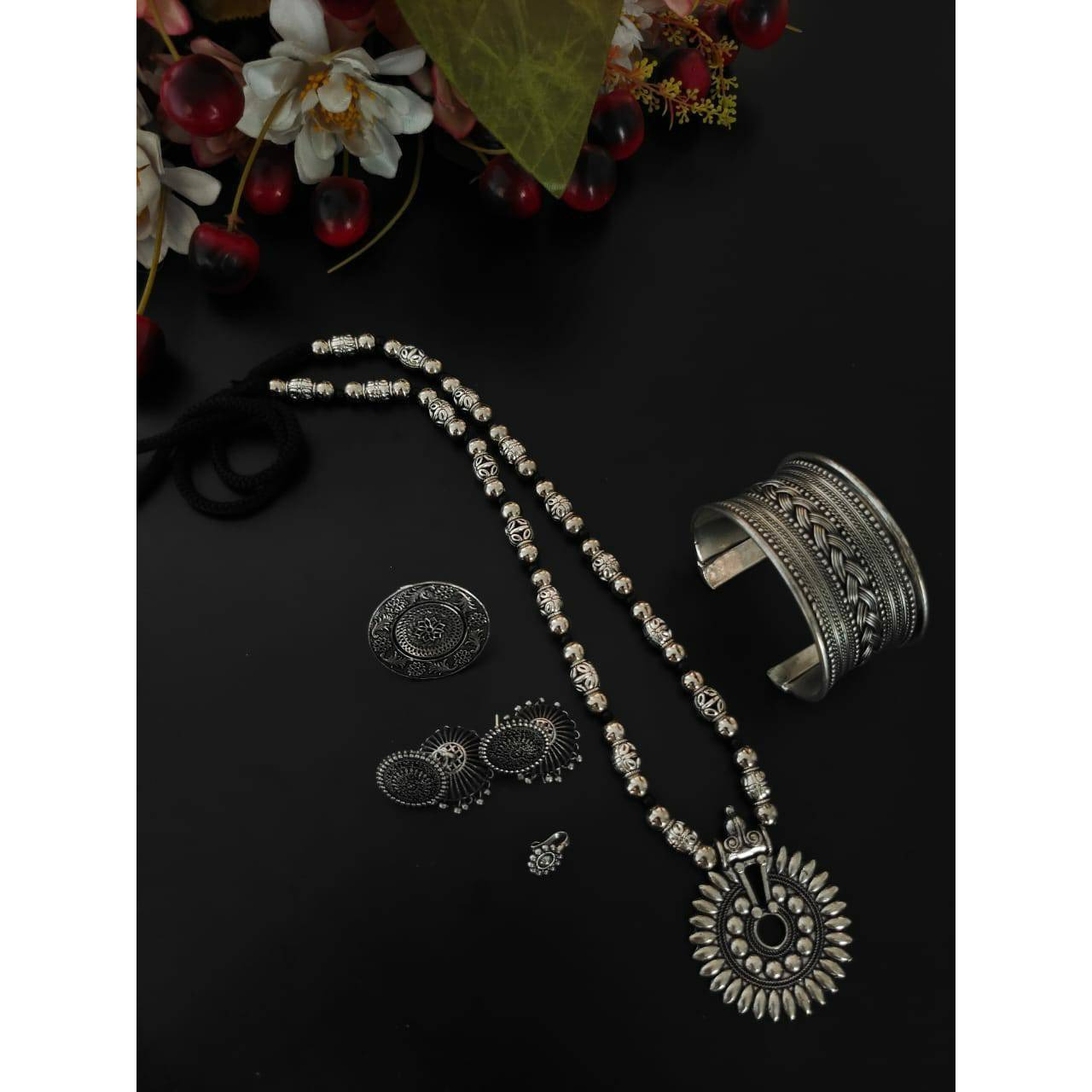 You can never go wrong with a statement oxidized necklace set. Beautifully ornated withfloral motifs, stones studded with dreamy white pearl drops, this unique necklace set willmake you fall in love with it instantly and is available in six different colours like red, green,black, dark blue, light blue, and multicolour. The gorgeous statement earrings add a bling toyour outfit. Pair it with your saree, low neck kurta, or lehenga and look stunning It isnecessary to keep this product away from ha