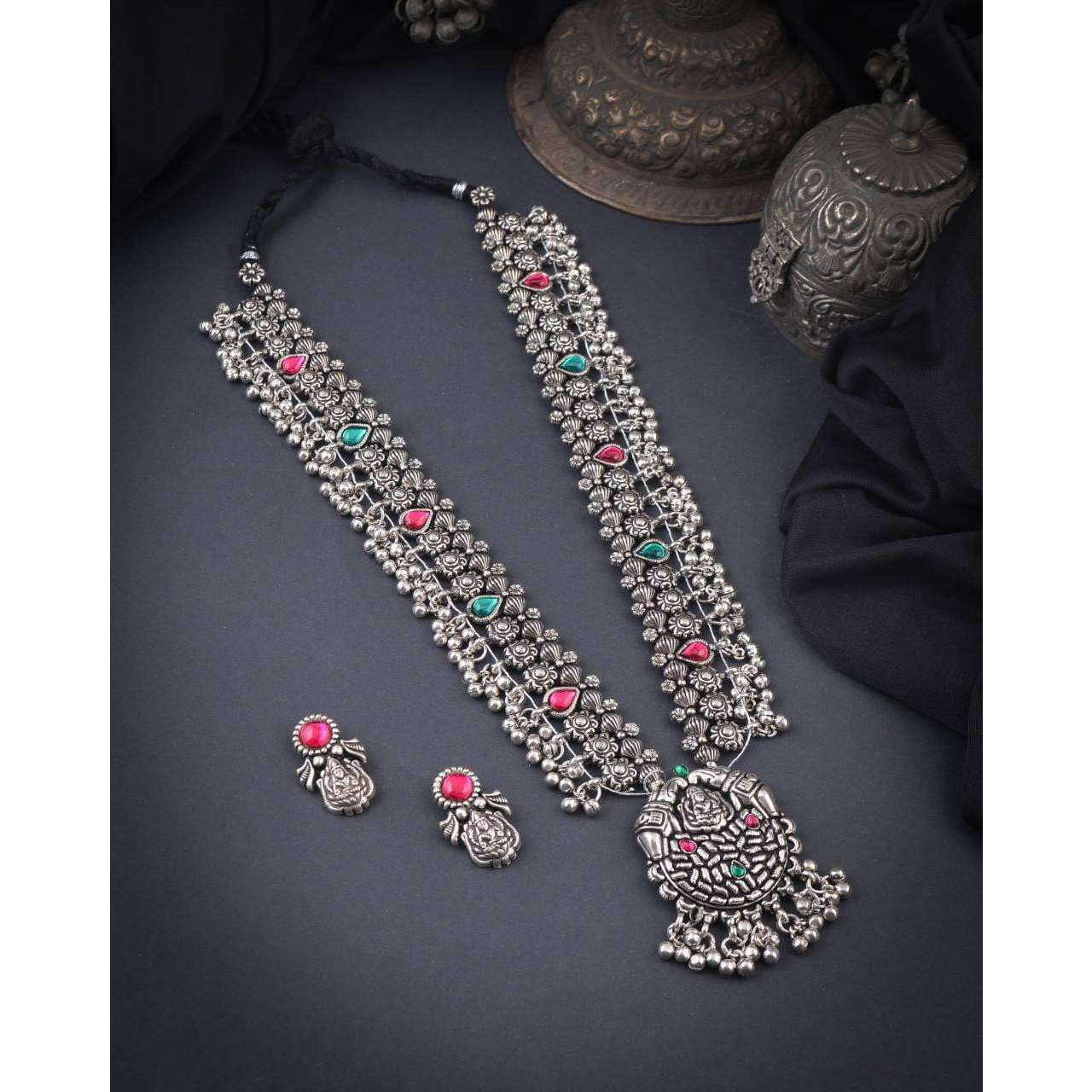 Steal the show with our Indian oxidized German silver long double necklace full combo set.It is a set of 6 beautifully designed pieces of jewellery, having a big long Haram oxidizednecklace, choker silver necklace, a pair of jhumka earrings, ring, a pair of bangles, and nosepin, hand-made with German oxidized silver to give it a dignified look. Style this with yourfavourite ethnics or Indo-western outfits, and you are ready for Navratri This hand-madeKolhapuri boho necklace set may have slight