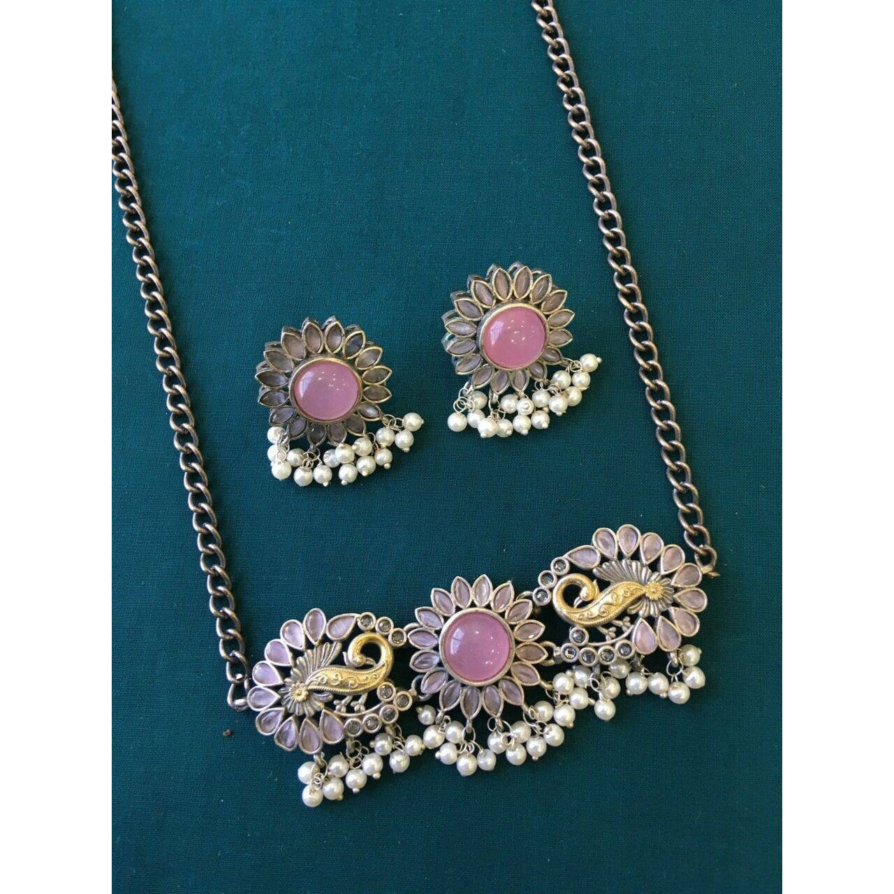 Impressively detailed and elaborate- this long necklace and earrings set, all in silver oxidised plating is a stunner. Find your inner gypsy vibe and express it with these statement jewels. Versatile enough to justify everyday or occasion dressing, these can be worn together or separately. Handmade by artisans in oxidized german silver, this set has been curated by our in house stylists specially for you.