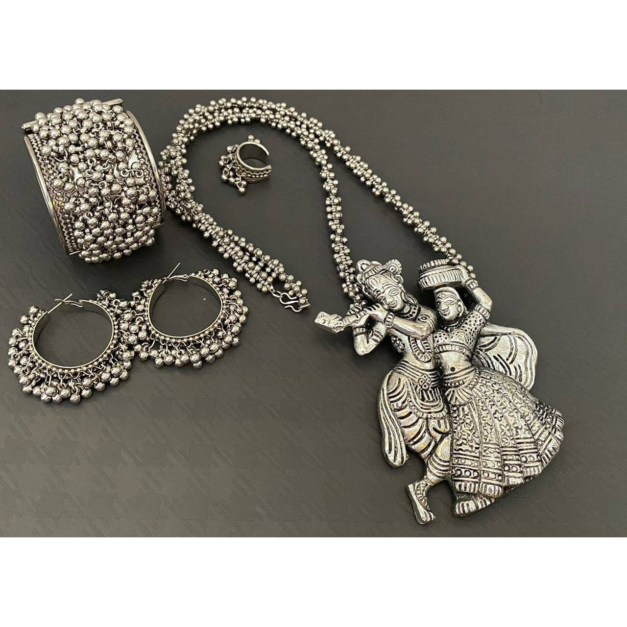 This beautiful set of 6 has a big long oxidized Haram necklace with a choker silver necklace, pair of jhumka earrings, a ring,pair of bangles, and a nose pin.Grab this beautiful set with any of the ethnic/ Indo western outfit and look unique in the crowdPremium quality set