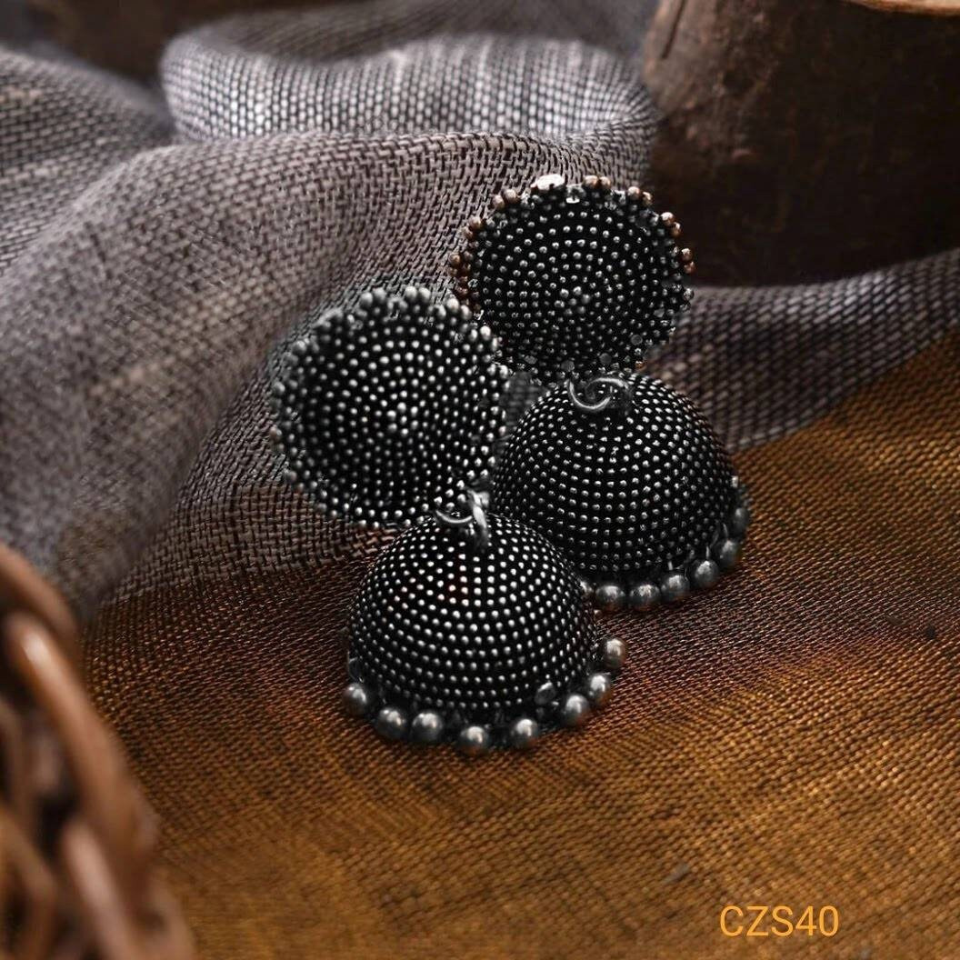 Nothing makes a woman look more elegant than a beautiful set of German Silver Indian jewelry. This set of German Silver bangles and kadas exude a lavish sheen from the black polish. Handcrafted with the utmost love and passion, this set of oxidized bangles adorns your wrists in a lovely fashion statement. The kadas come with shiny little bells that make a charming tune when worn together with the bangles. This set adds the perfect amount of oomph to your ethnic outfits. Wear it with a traditiona