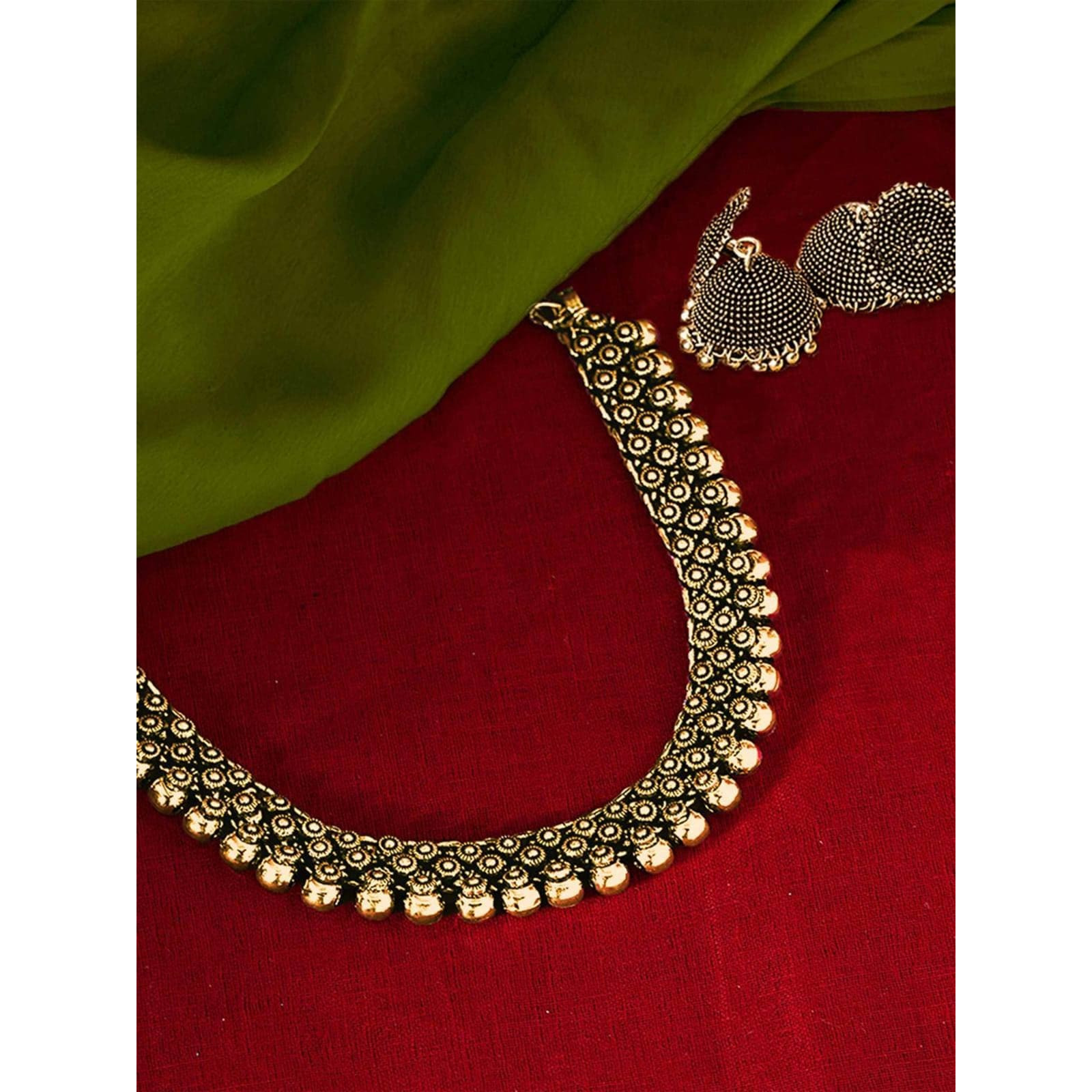 Versatile and Bold, This necklace features intricate motifs with playful ghungroos that gracefully falls on your neck to give stunning look. This necklace is a one stop solution to achieve a rich and vibrant look. Style this up with our sarees or go bold with indo-western outfits for a classy boho look!