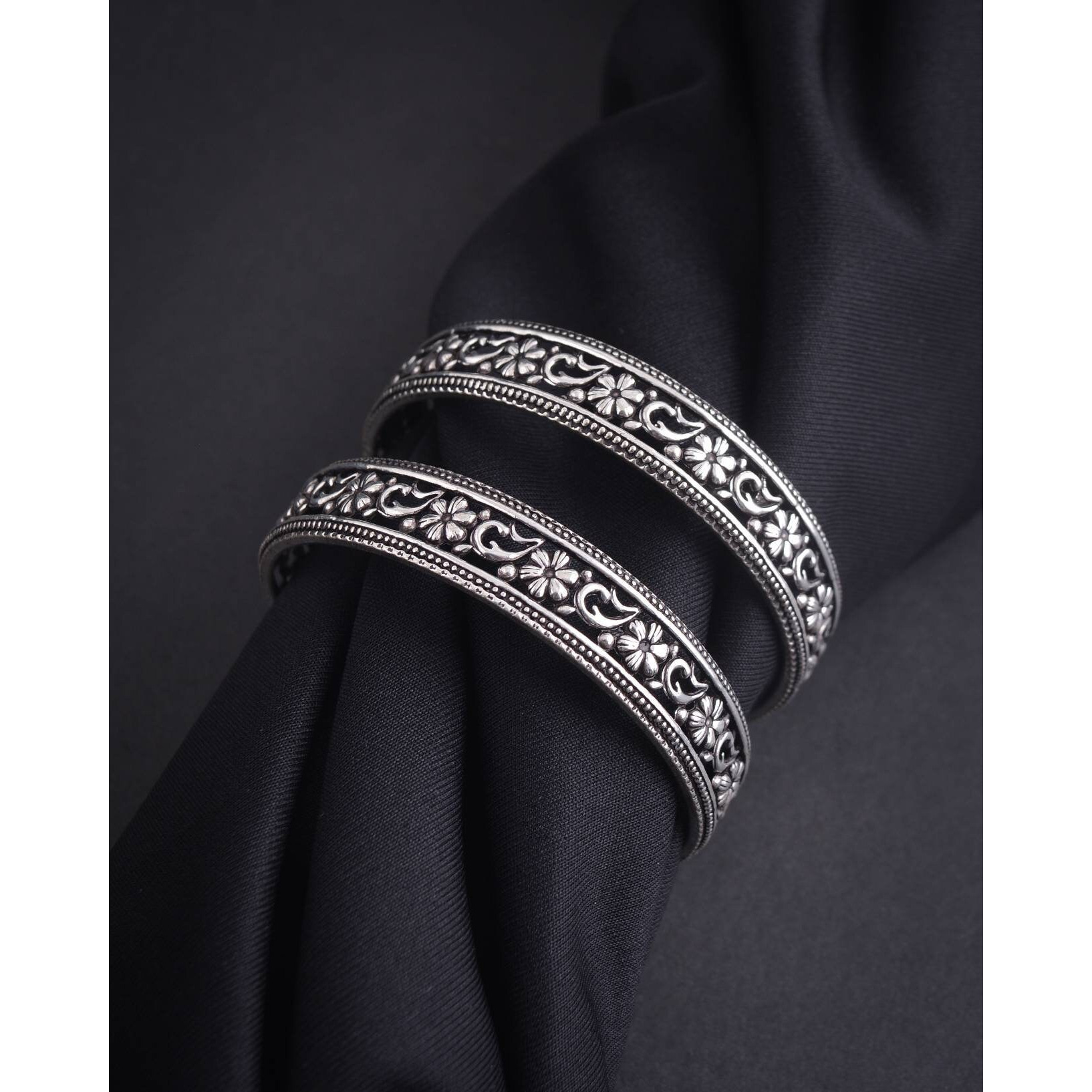 A stunning choker necklace that will leave you feeling pretty all day long with its repeating detailed floral designs. This choker necklace set is crafted in oxidized silver that gives a raw and rustic feel to it. The matching floral earrings just add more beauty making it eye-catchy. This set will complement your office wear to your ethnics.