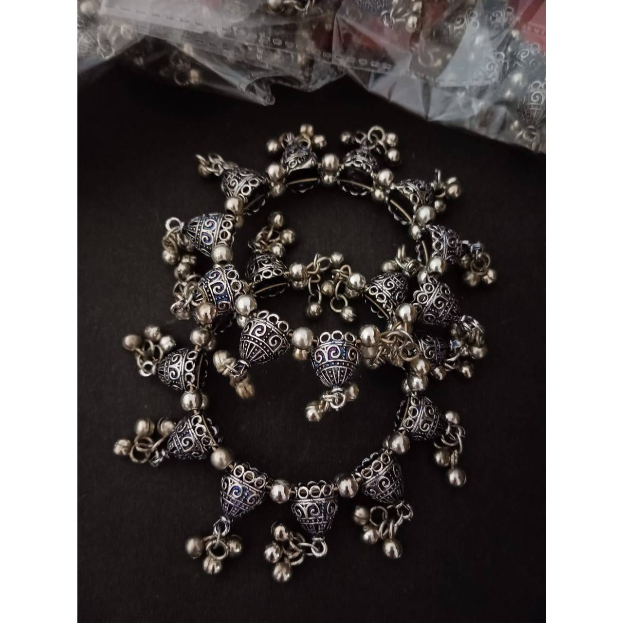 We love how layered necklaces give a rich character to the look This black and silver combination multilayered Oxidised Necklace features playful floral designs and beads, that will add its charm to your look. A necklace that will be an valuable addition to your wardrobe. It is versatile and would go with any of your casual outfit or ethnics.