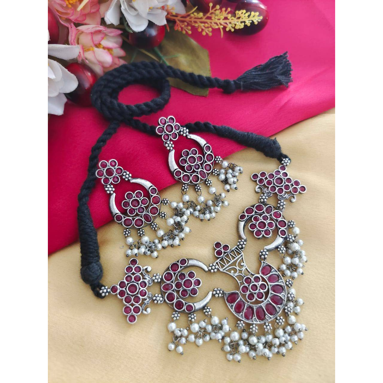 Delve into the world of finely crafted classics that powerfully capture the beauty of modern Indian craftsmanship. This elegant pair of oxidised silver plated earrings and maangtikka dressed up with tinkling pearl hangings and delicate filigree & peacock details, is one of our personal favourites. These earrings make effortless addition to your white hued attires, be it indian or western. A funky pair that can be used practically everyday and with various outfits and will definitely add to your