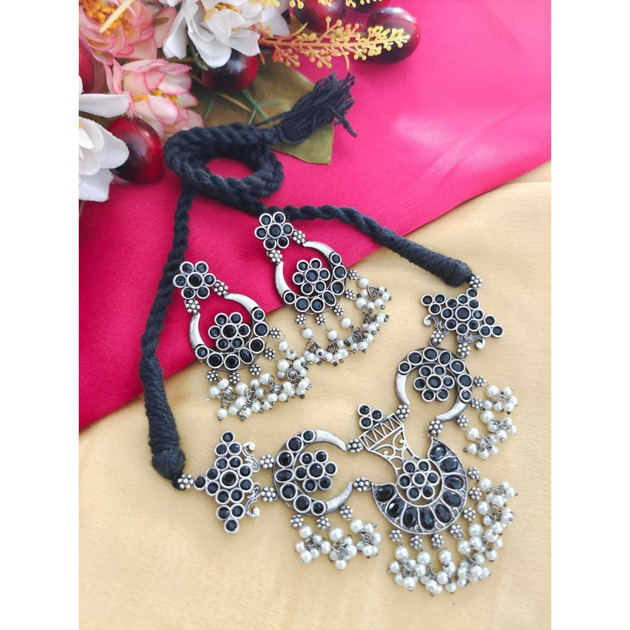Delve into the world of finely crafted classics that powerfully capture the beauty of modern Indian craftsmanship. This elegant pair of oxidised silver plated earrings and maangtikka dressed up with tinkling pearl hangings and delicate filigree & peacock details, is one of our personal favourites. These earrings make effortless addition to your white hued attires, be it indian or western. A funky pair that can be used practically everyday and with various outfits and will definitely add to your
