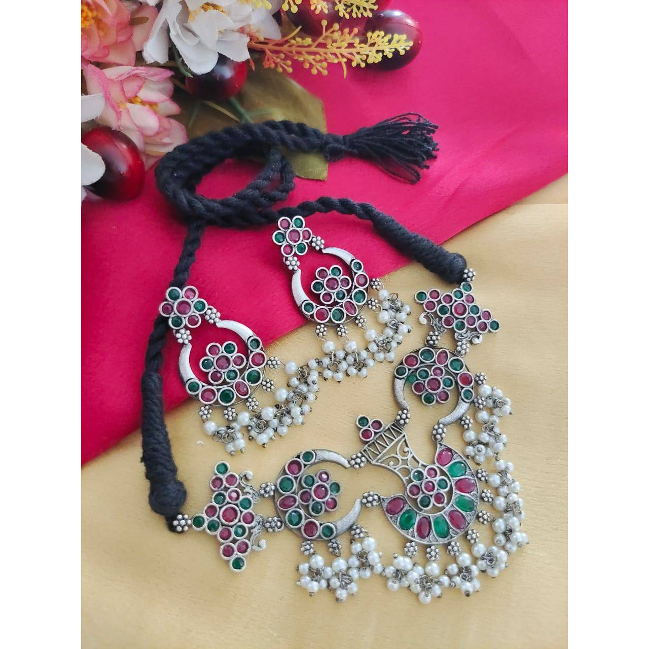 Delve into the world of finely crafted classics that powerfully capture the beauty of modern Indian craftsmanship. This elegant pair of oxidised silver plated earrings and maangtikka dressed up with tinkling pearl hangings and delicate filigree & peacock details, is one of our personal favourites. These earrings make effortless addition to your white hued attires, be it indian or western. A funky pair that can be used practically everyday and with various outfits and will definitely add to your