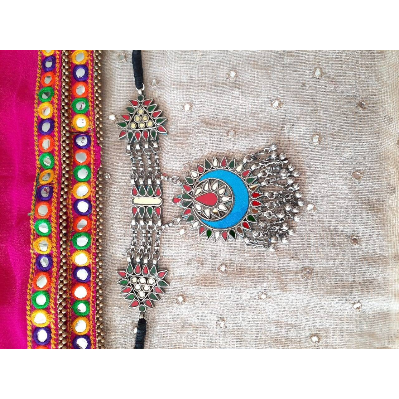This Afghani Choker Necklace is crafted in oxidized silver that is a perfect amalgamation of beautiful multi-color enamel work and perky ghungroos that will lace your collar to give you a rich and vibrant look. Style this up for a high-statement boho look.
