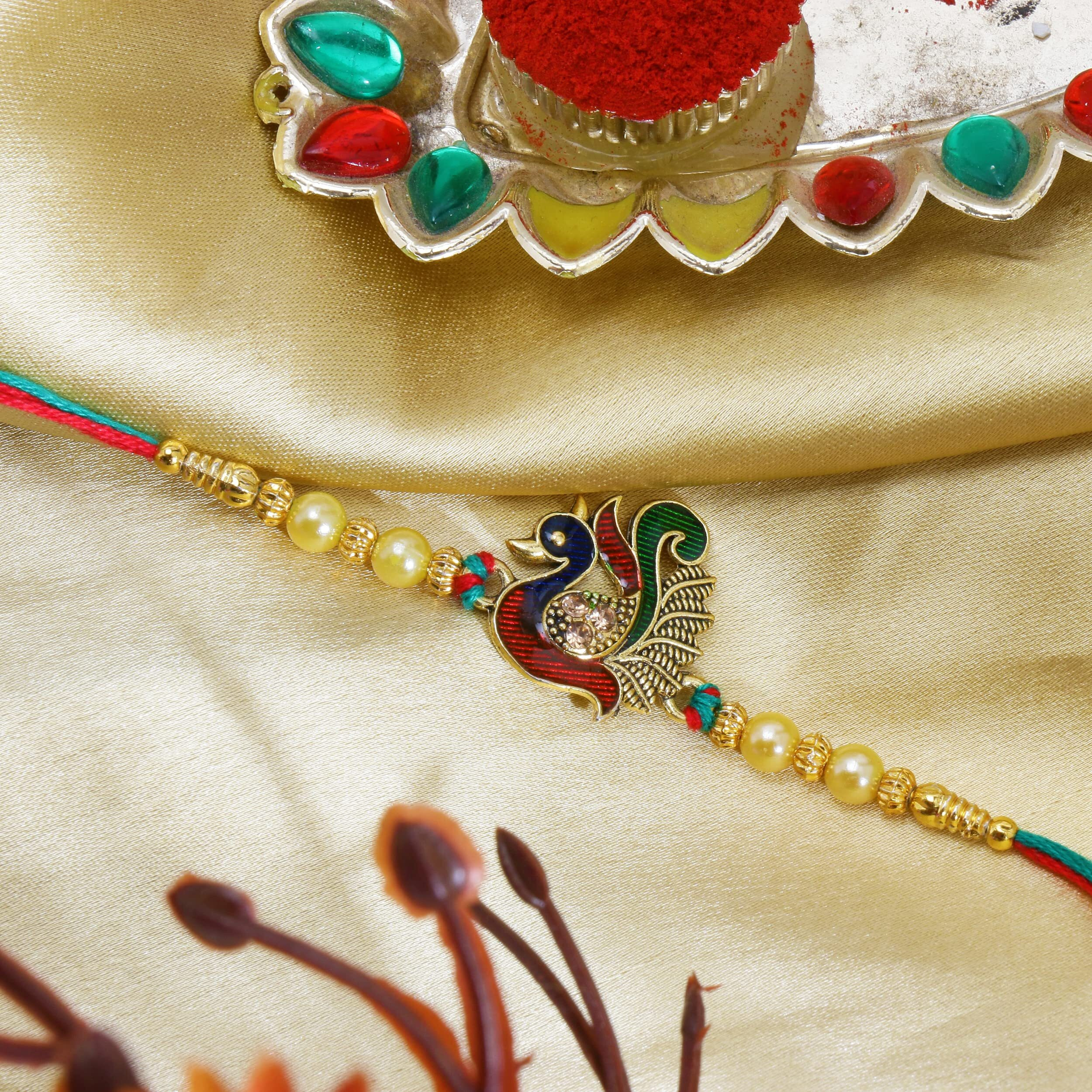 Riddhika Ventures Stunning Gold Plated Designer Peacock and Auspicious kalash Rakhi with Roli Chawal and Greeting Card (P7)