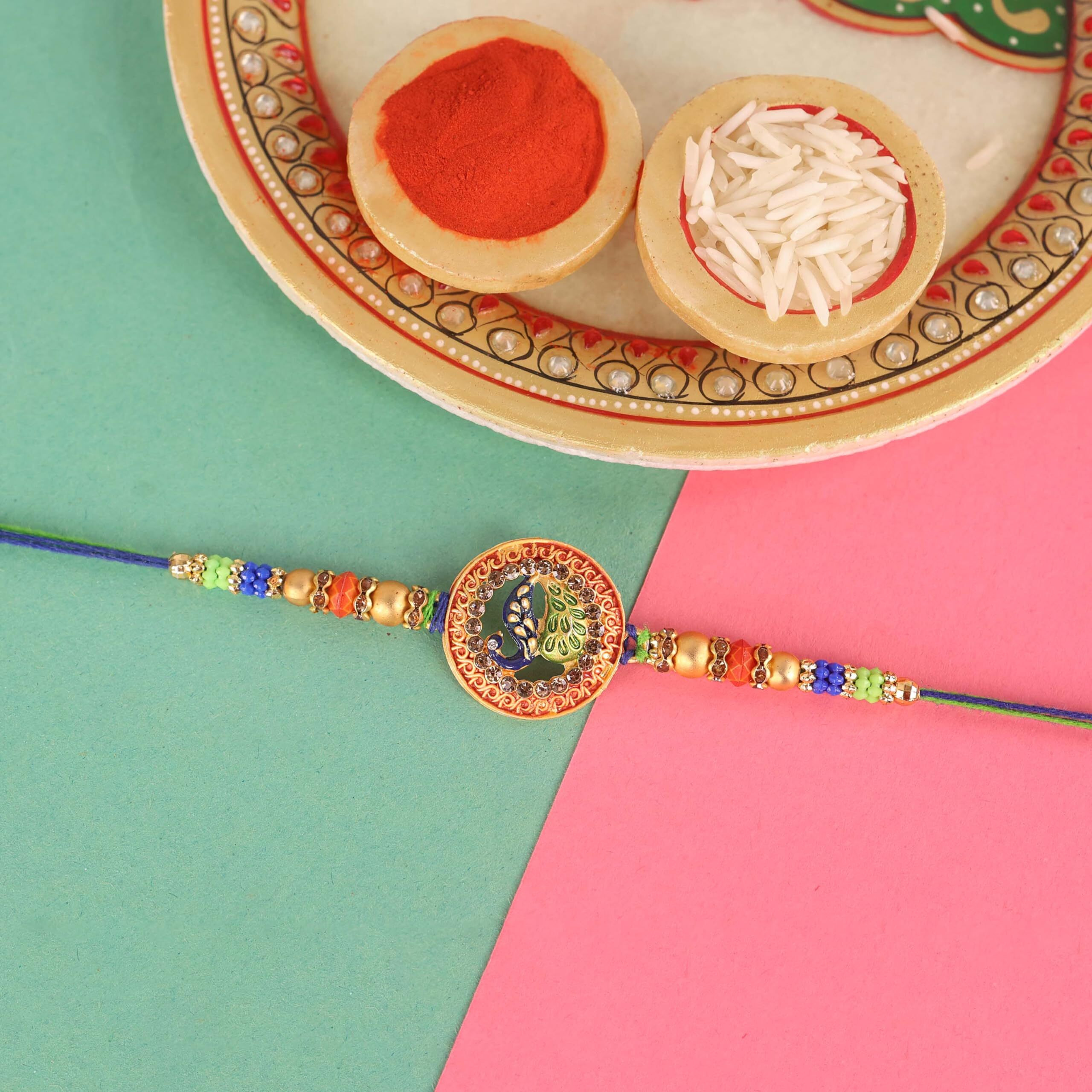 Riddhika Ventures Stylish Peacock Feather and Kundan Rakhi with Roli Chawal and Greeting Card (K7)