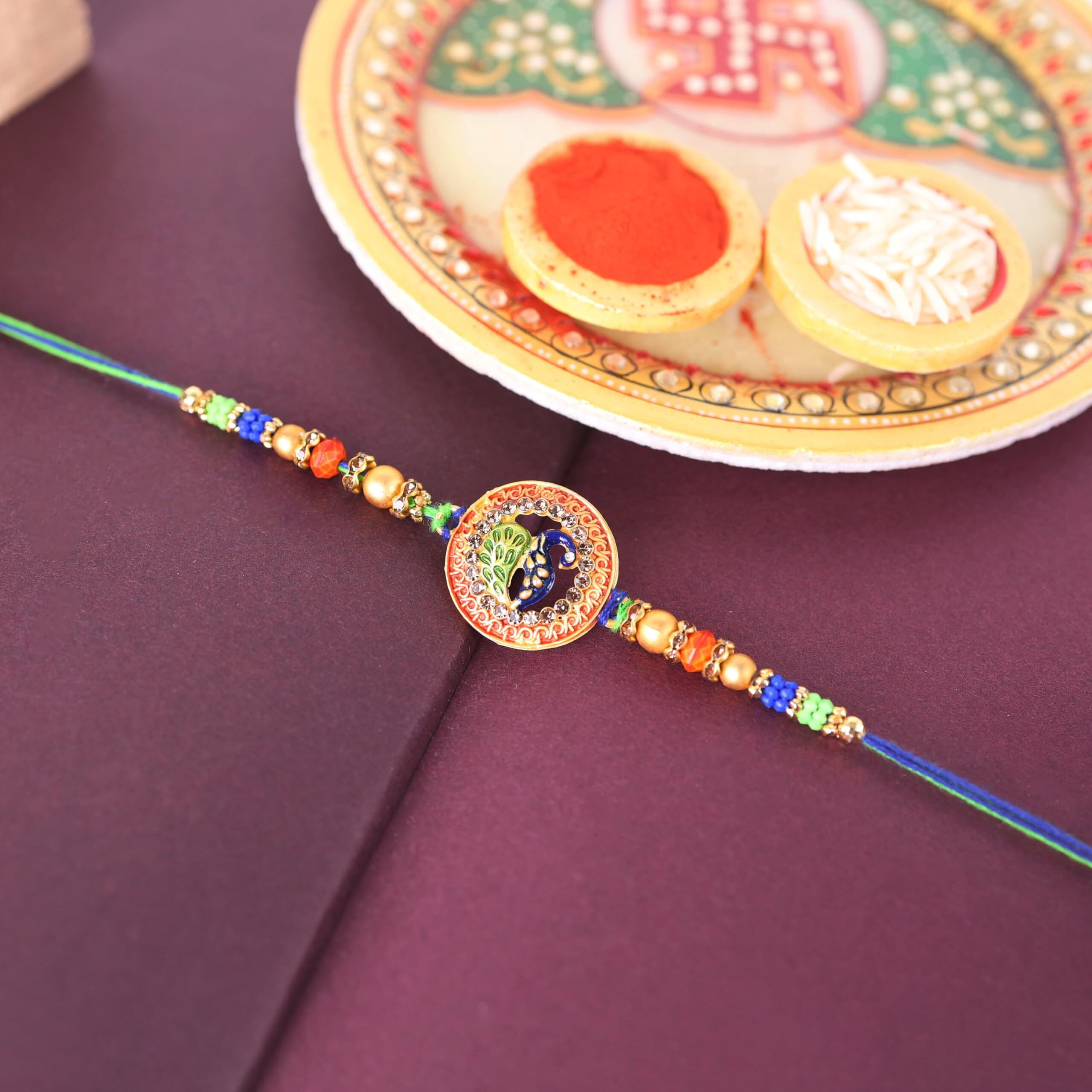 Riddhika Ventures Stylish Peacock Feather and Kundan Rakhi with Roli Chawal and Greeting Card (K7)