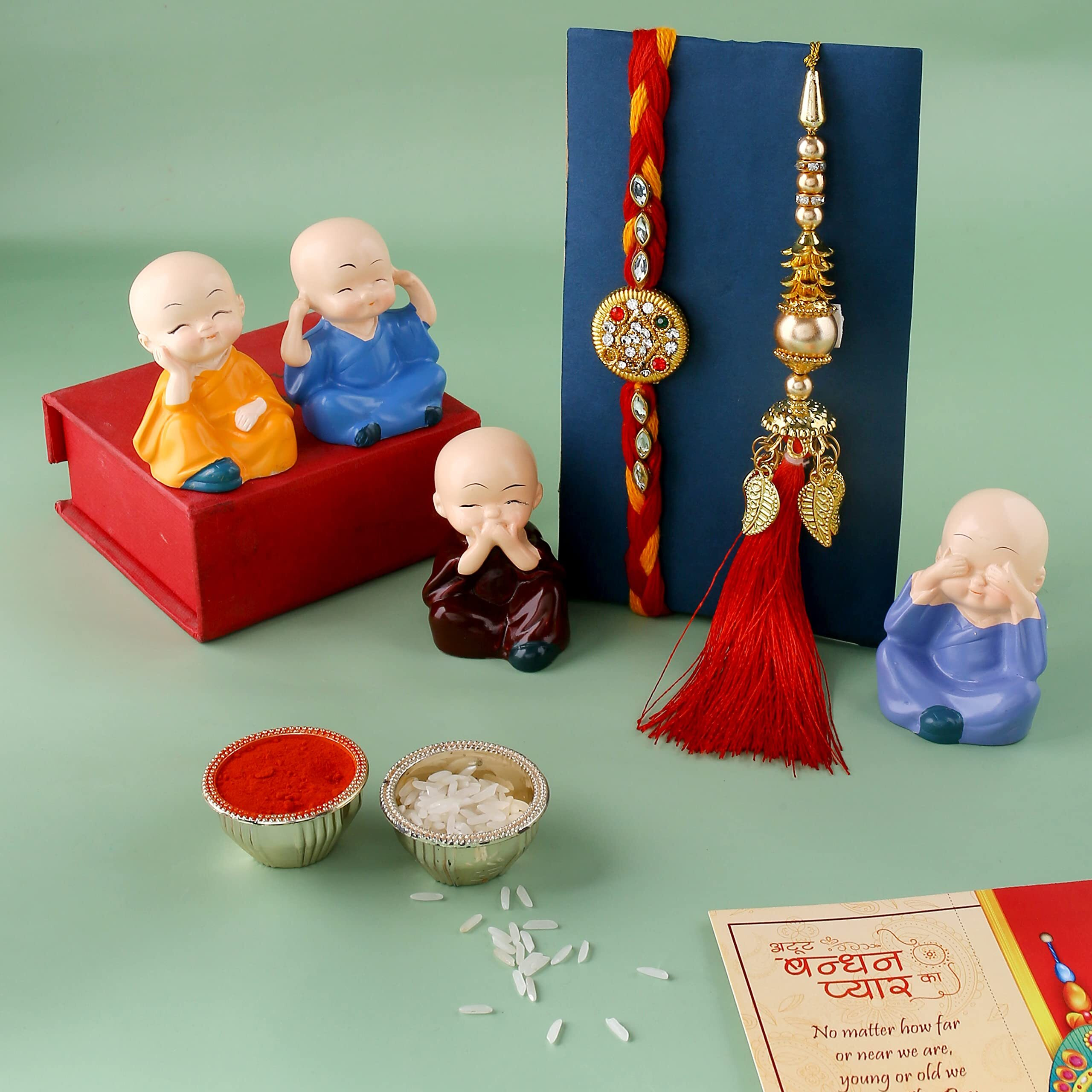 Rakhi Gift Combo Set of 2 Rakhi for Brother and Bhabhi with Showpiece Gift - Kundan, Lumba Rakhi with Set of 4 Miniature Buddha Monk Figurines Showpiece with Greeting Card