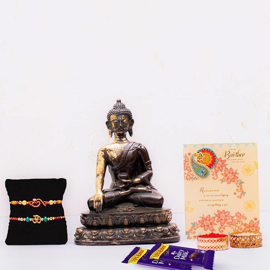 ARCHIES Rakhi for Brother Rakshabandhan Combo of 1 Majestic Ganesha Idol, 2 Auspicious Om Rakhis and 2 Dairy Milk Chocolates 13.2gm With 1 Roli & Chawal Set-10gm & Greeting Card (Pack of 7)