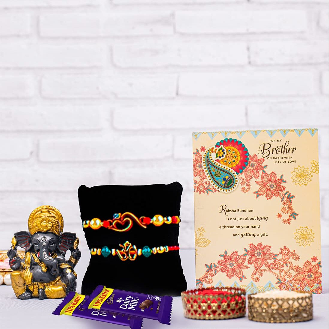 ARCHIES Marvelous Rakhi for Brother Rakshabandhan Combo of 1 Rakhi, 1 Ganesh Laxmi Coin With 1 Roli & Chawal-10gm, 1 Exotic Assorted Chocolates-30 gms(Dates and Almonds) & Greeting Card (Pack of 5)