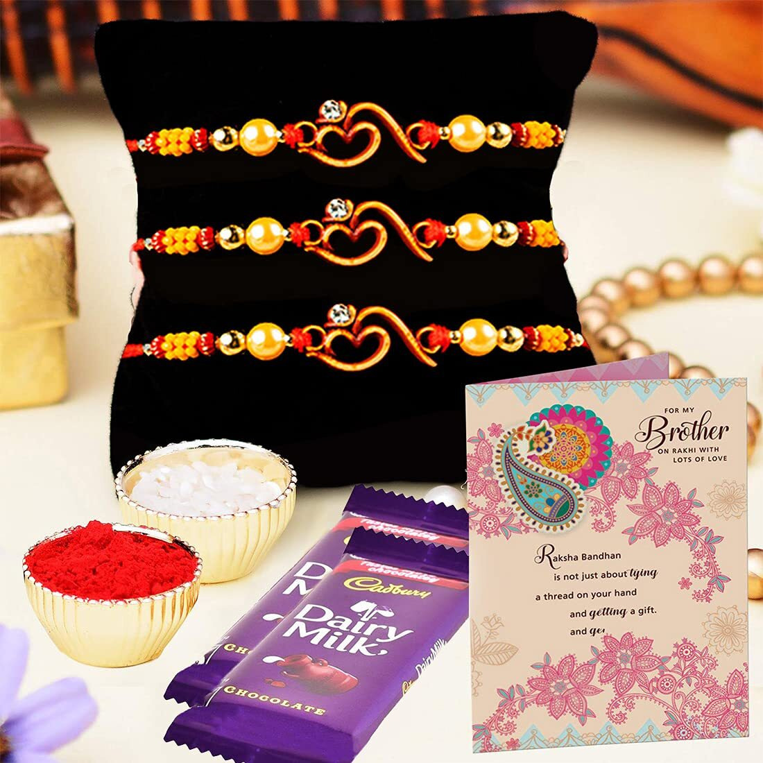 ARCHIES Marvelous Rakhi for Brother Rakshabandhan Combo of 1 Rakhi, 1 Ganesh Laxmi Coin With 1 Roli & Chawal-10gm, 1 Exotic Assorted Chocolates-30 gms(Dates and Almonds) & Greeting Card (Pack of 5)