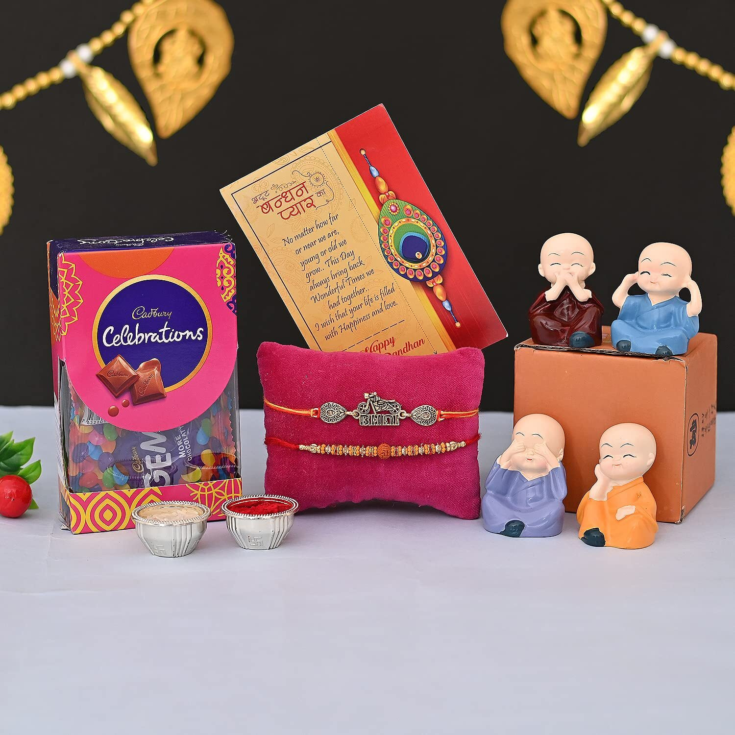 CraftVatika Rakhi For Brother with Chocolate Gift Combo Set of Cadbury Celebration Chocolates Gift Pack Box With Monka Buddha Showpiece, 2 Rakhi Set Dora, Bike Bhai Rakhi, Rudraksh Rakhi, Greeting Card