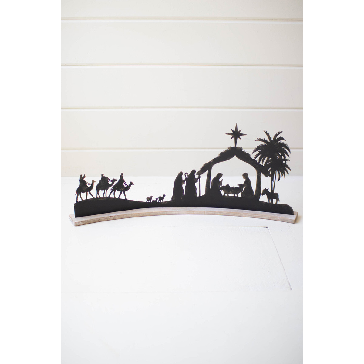 BLACK METAL NATIVITY ON A CURVED WHITE WOOD BASE